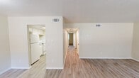 Located at 1201 South Johnson Street in Alvin, Texas, this single-story residence offers a practical and well-organized layout across two bedrooms and two bathrooms. Light wood-style flooring runs throughout the home, lending a clean, cohesive look to every room. The living room is a comfortable, open space highlighted by a large window that invites natural light and offers views of the surrounding greenery. It connects seamlessly to the dining area, creating an easy flow for everyday living. The kitchen is designed for efficiency, featuring white cabinetry, granite-style countertops, a stainless steel sink, and white appliances including a range and refrigerator. A pantry provides additional storage. A central hallway leads to the two bedrooms, both finished with the same light flooring. The primary bedroom offers a generous footprint with ample room for furnishings, while the secondary bedroom includes a ceiling fan and a closet with bifold doors. Three closets total are distributed throughout the home for added storage convenience. Both bathrooms are clean and functional, each featuring a tub-shower combination with brushed nickel fixtures. A dedicated laundry area completes this well-appointed, move-in-ready residence.