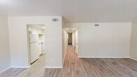 Located at 1201 South Johnson Street in Alvin, Texas, this single-story residence offers a practical and well-organized layout across two bedrooms and two bathrooms. Light wood-style flooring runs throughout the home, lending a clean, cohesive look to every room. The living room is a comfortable, open space highlighted by a large window that invites natural light and offers views of the surrounding greenery. It connects seamlessly to the dining area, creating an easy flow for everyday living. The kitchen is designed for efficiency, featuring white cabinetry, granite-style countertops, a stainless steel sink, and white appliances including a range and refrigerator. A pantry provides additional storage. A central hallway leads to the two bedrooms, both finished with the same light flooring. The primary bedroom offers a generous footprint with ample room for furnishings, while the secondary bedroom includes a ceiling fan and a closet with bifold doors. Three closets total are distributed throughout the home for added storage convenience. Both bathrooms are clean and functional, each featuring a tub-shower combination with brushed nickel fixtures. A dedicated laundry area completes this well-appointed, move-in-ready residence.