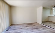 Located at 1434 4th St in Sacramento, CA, this 3-story townhome offers 1,570 square feet of living space across 2 bedrooms and 4 bathrooms. The ground floor (420 sq ft) features a spacious attached two-car garage with concrete flooring, an automatic garage door opener, and a wood-railed staircase leading to the upper levels. The main living floor (560 sq ft) hosts an open-plan kitchen and living room. The kitchen is equipped with stainless steel appliances including a range and refrigerator, white cabinetry, and light hardwood-style flooring. The living room features a fireplace with a raised hearth, matching light hardwood-style flooring, and a sliding glass door with vertical blinds that provides outdoor access and natural light. A second staircase connects this level to the upper floor. The top floor (590 sq ft) contains both bedrooms, each carpeted and featuring high ceilings that add a sense of spaciousness. The 220 sq ft primary bedroom includes a built-in closet. Bathrooms throughout the home are clean and functional, with at least one full bath featuring a soaking tub and shower combo with chrome fixtures. Two dedicated closets and a hallway round out the floor plan.