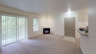 Located at 16900 SE 272nd St in Covington, WA, this single-floor residence offers a well-organized layout designed for comfortable everyday living. The living room serves as the heart of the home, featuring a built-in fireplace that adds warmth and character to the space. Soft carpeting flows throughout, while vertical blinds and large sliding glass doors lead to an outdoor balcony area, flooding the room with natural light and offering views of surrounding greenery.

The kitchen is thoughtfully designed with light wood cabinetry, white appliances including a range and refrigerator, and a breakfast peninsula that provides additional counter space and a natural divide between the kitchen and living areas. The layout allows for an open, connected feel between these shared spaces.

The bedrooms are generously sized, each featuring plush carpeting, baseboard heating, and windows that frame lush, tree-lined views, creating a calm and peaceful atmosphere. The neutral, light-toned walls throughout the residence give the space a clean, airy quality that is easy to personalize.

Overall, this residence offers a practical and inviting layout with functional features, comfortable finishes, and a strong connection to the natural surroundings of Covington, Washington.