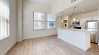 Located in Indianapolis, IN 46204, this 3-bedroom, 1-bathroom residence offers a thoughtfully designed single-floor layout that maximizes functionality. The open-concept living area is bright and airy, featuring light wood-look flooring, tall ceilings, and multiple windows fitted with blinds that invite abundant natural light. The kitchen flows seamlessly into the living space via a peninsula counter topped with granite, complemented by white cabinetry, pendant lighting, a microwave, and in-unit washer — providing everyday convenience. The three bedrooms are carpeted and well-proportioned, with the primary bedroom offering a closet and ample natural light. Additional bedrooms also feature closets and windows with views of the Indianapolis skyline. The bathroom is clean and functional, equipped with a granite-topped vanity with white cabinetry, a large mirror with overhead lighting, and tile flooring. A hallway connects the rooms efficiently, and a dedicated closet provides extra storage. The neutral, light color palette throughout creates a cohesive and inviting ambiance, well-suited for urban living in the heart of downtown Indianapolis.