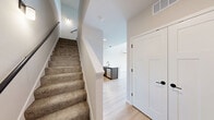 Located at 8421 Mansion Hill Ave in Madison, Wisconsin, this two-floor residence offers a thoughtfully designed layout spread across a generously sized main level and a lofted upper level. The main floor commands attention with its dramatically tall ceilings and an abundance of natural light, enhanced by large sliding glass doors that open onto a private balcony overlooking lush greenery. A wall-mounted mini-split climate system provides efficient heating and cooling throughout. Light hardwood-style flooring runs throughout the main level, lending a clean, contemporary aesthetic. The kitchen is a standout feature, equipped with stainless steel appliances including a refrigerator, electric range, and microwave, all complemented by rich dark wood cabinetry, white quartz countertops, a peninsula with an undermount sink, and matte black fixtures. The bathroom is finished with a full soaking tub and shower combo, wood-look flooring, and matte black hardware accents. A hallway connects the main living areas efficiently. Upstairs, the lofted upper level features plush carpeting, a ceiling fan with light, a double-door closet, and an open railing overlooking the main floor below, creating a sense of openness and connectivity between levels.