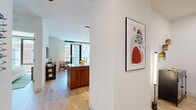 Located at 218 E Grand Ave in Chicago's vibrant Streeterville neighborhood, this thoughtfully designed one-bedroom, one-bathroom residence offers a refined urban living experience across a single floor. The open-concept layout seamlessly connects the kitchen, dining, and living areas, creating a cohesive and functional space bathed in natural light.

The kitchen is a standout feature, showcasing two-tone cabinetry with matte black upper cabinets and warm walnut lower cabinets, crisp white quartz countertops, a vertical white tile backsplash, stainless steel appliances including a gas range, and a peninsula with seating — ideal for casual dining or entertaining.

The living area is anchored by floor-to-ceiling windows and a glass balcony door that frame sweeping city views, filling the space with abundant natural light. Light hardwood flooring runs throughout, enhancing the airy, contemporary atmosphere.

The bedroom is a comfortable retreat featuring large windows with city views, light-filled and serene. The full bathroom is elegantly appointed with a wood-toned vanity, an illuminated mirror, large-format stone tiles, and a glass-enclosed walk-in shower with matte black fixtures. This residence offers a polished, modern aesthetic in the heart of Chicago.