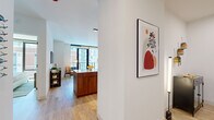 Located at 218 E Grand Ave in Chicago's vibrant Streeterville neighborhood, this thoughtfully designed one-bedroom, one-bathroom residence offers a refined urban living experience across a single floor. The open-concept layout seamlessly connects the kitchen, dining, and living areas, creating a cohesive and functional space bathed in natural light.

The kitchen is a standout feature, showcasing two-tone cabinetry with matte black upper cabinets and warm walnut lower cabinets, crisp white quartz countertops, a vertical white tile backsplash, stainless steel appliances including a gas range, and a peninsula with seating — ideal for casual dining or entertaining.

The living area is anchored by floor-to-ceiling windows and a glass balcony door that frame sweeping city views, filling the space with abundant natural light. Light hardwood flooring runs throughout, enhancing the airy, contemporary atmosphere.

The bedroom is a comfortable retreat featuring large windows with city views, light-filled and serene. The full bathroom is elegantly appointed with a wood-toned vanity, an illuminated mirror, large-format stone tiles, and a glass-enclosed walk-in shower with matte black fixtures. This residence offers a polished, modern aesthetic in the heart of Chicago.