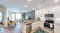 Located at 2001 Plateau Vista Blvd in Round Rock, TX, this one-bedroom, one-bathroom residence is thoughtfully designed to maximize both comfort and functionality. The open-concept layout seamlessly connects the kitchen and living room, creating an inviting, cohesive living space bathed in natural light from large windows.

The kitchen is a standout feature, showcasing white shaker cabinetry, a subway tile backsplash, stainless steel appliances, and a peninsula with quartz countertops that doubles as a breakfast bar with seating. Wood-look flooring flows throughout the main living areas, adding warmth and continuity.

The living room offers a relaxed atmosphere, highlighted by a ceiling fan, a private balcony-access door, and generous wall space. A dedicated closet area houses an in-unit washer and dryer, providing added convenience.

The bedroom is a calm retreat with soft carpet, a ceiling fan, large windows that invite natural light, and ample space for furnishings. The bathroom features a clean, modern design with white cabinetry, a quartz vanity countertop, a framed mirror, and a walk-in shower with tile surround. Light wood-look flooring and crisp white walls complete the polished aesthetic throughout the home.