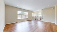 Located in Milford, Ohio, this well-appointed three-story home offers a thoughtfully designed layout across three distinct levels. The ground floor houses a generously sized garage with an automatic opener, providing convenient interior access, along with additional utility space. The main living level serves as the heart of the home, featuring a bright living room with gleaming hardwood floors, large windows that flood the space with natural light, and an open staircase with classic wood and iron railings. The kitchen is outfitted with warm wood cabinetry, stainless steel appliances including a full-size refrigerator, range, and microwave, all complemented by hardwood flooring. A full bathroom on this level features rich wood vanity cabinetry with granite-style countertops. The upper floor hosts three bedrooms, including a spacious primary suite with vaulted ceilings, a ceiling fan, plush carpeting, and a walk-in closet with built-in shelving. Additional bedrooms are carpeted and offer ample natural light through large windows with neighborhood views. Carpeted staircases with wood handrails connect all three levels smoothly. A balcony and den round out the home's versatile living spaces, creating a comfortable and functional residence suited for everyday living.