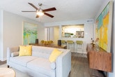 Located in Marietta, Georgia, this thoughtfully designed single-floor residence offers a comfortable and contemporary living experience across several well-appointed spaces. The living room serves as the heart of the home, centered around a striking fireplace framed by a rich wood-paneled accent wall. Wood-look flooring, abundant natural light from multiple windows, and direct access to an entry door create a warm and welcoming atmosphere. The kitchen is outfitted with stainless steel appliances including a gas range, a granite-look countertop, crisp white cabinetry, and a stylish subway tile backsplash — combining function with modern aesthetics. Multiple bedrooms provide restful retreats, each featuring plush carpeting, ceiling fans with lighting, and windows that invite natural light. One bedroom showcases a bold, creative office nook with a dramatic black-and-white striped accent wall, wooden desk, and vibrant yellow seating. The bathrooms are finished with dark wood vanities, granite-topped counters, hardwood-style flooring, and tub-shower combinations. Throughout the residence, a cohesive design palette of soft grays, warm neutrals, and bold accent colors creates an inviting and visually dynamic living environment.