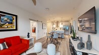 Located in Melbourne, FL, this well-appointed 2-bedroom, 2-bathroom single-floor residence offers a thoughtfully designed open-concept layout. Light wood-look flooring flows throughout, creating a cohesive and contemporary aesthetic. The combined kitchen and living area serves as the heart of the home, featuring a gourmet kitchen with white shaker cabinetry, a decorative tile backsplash, stainless steel appliances including a French door refrigerator and double wall ovens, a central island with pendant lighting, and a wall-mounted range hood. Track lighting adds to the kitchen's functionality. A sliding barn door connects the living area to additional spaces, lending a modern farmhouse touch. The living room is bright and welcoming, with large windows that invite natural light. Both bedrooms are comfortably sized, each with ceiling fans and ample closet space, including a dedicated walk-in closet with built-in shelving. The two bathrooms are finished with wide vanities and wood-look tile flooring. A dedicated laundry room includes cabinetry, a utility sink, and overhead shelving. The layout also includes a hallway, two closets, and access to a private patio, rounding out this functional and stylish residence.