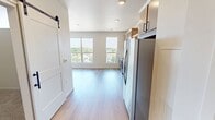 This 490 square foot apartment in Fargo, ND, presents a harmonious blend of functionality and contemporary design. The open floor plan maximizes space utilization, creating a sense of airiness throughout the single-story dwelling. Large windows dominate one wall, flooding the interior with natural light and offering expansive views of the surrounding area.

The kitchen is a standout feature, boasting sleek stainless steel appliances, including a refrigerator, built-in microwave, and oven. Light-toned cabinetry with modern hardware provides ample storage, while a white tile backsplash adds a touch of sophistication. The kitchen's layout is designed for efficiency, with a seamless flow that integrates it into the living space.

The bathroom continues the modern aesthetic with a floating vanity, large mirror, and crisp white fixtures. Wood-look flooring extends throughout the apartment, including the bathroom, lending warmth and continuity to the space. Recessed lighting fixtures are strategically placed to provide even illumination.

Despite its compact size, the apartment doesn't compromise on style or amenities. The thoughtful design creates distinct areas for living, dining, and sleeping within the open layout. High ceilings enhance the sense of spaciousness, while the neutral color palette offers a canvas for personalization. This apartment exemplifies efficient urban living with a contemporary flair.