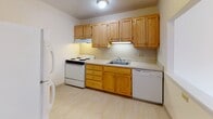 Located at 80 Gardner Street in the Allston neighborhood of Boston, MA, this single-floor unit offers a well-organized layout with a practical and comfortable design throughout. The living area is highlighted by warm hardwood floors, neutral walls, and a large window that allows natural light to fill the room while offering views of the surrounding brick-building streetscape. A wall-unit air conditioner and baseboard heating provide year-round climate control.

The kitchen is efficiently designed with ample honey-toned wooden cabinetry, offering generous storage both above and below the counter. It is equipped with a white electric range, dishwasher, refrigerator, and a double-basin sink, all set against light countertops and easy-to-maintain tile flooring.

The bedrooms continue the warm hardwood flooring theme, with one room featuring a pass-through window opening to the kitchen and a closet, while another bedroom offers dual closets, providing excellent storage capacity. Both rooms are bright and versatile.

The bathroom is distinctly finished with classic blue ceramic wall tiles lining the tub-shower surround and lower walls, complemented by light wood-toned flooring and clean white fixtures. The overall ambiance of the unit is clean, functional, and well-maintained, making it a practical home in a convenient Boston location.
