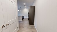 This single-story, one-bedroom, one-bathroom home offers a thoughtfully designed layout that maximizes every square foot. Light-toned wood-look flooring flows consistently throughout, creating a cohesive and clean aesthetic across all rooms.

The open-concept kitchen and living area serves as the heart of the home. The kitchen is appointed with rich, dark espresso cabinetry, granite countertops, and a full suite of black appliances, including a refrigerator, range, and microwave. A central island with a granite surface and built-in sink provides additional prep space and is illuminated by stylish pendant lighting overhead. Recessed lighting further brightens the space.

The living area is bright and airy, benefiting from natural light through windows fitted with blinds, a ceiling fan, and direct access to the exterior via a rear door. The bedroom is a comfortable, well-proportioned retreat with its own ceiling fan, a large window for natural light, and access to two closets for generous storage.

The bathroom features dark cabinetry with a granite-topped vanity, a large mirror, accessible grab bars, a walk-in shower, and large-format tile flooring. Additional conveniences include a dedicated laundry area and an entrance foyer, rounding out this efficiently designed and modern home.