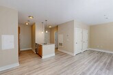 This thoughtfully designed studio in Medford, MA offers a bright, open-concept layout with light hardwood-style flooring that flows seamlessly throughout the space. The living area is bathed in natural light from large windows and a sliding glass door that opens to an outdoor patio, offering views of lush greenery and creating an airy, welcoming ambiance.

The kitchen is a standout feature, equipped with stainless steel appliances including a range, microwave, refrigerator, and dishwasher. Warm wood cabinetry is paired with white upper cabinets and a classic subway tile backsplash. A peninsula with pendant lighting and a single-basin sink provides additional counter space and serves as a natural divider between the kitchen and living area.

The bathroom is finished with large-format tile flooring, a wood-toned vanity with a white countertop, a framed mirror, and a tiled shower. Grab bars are installed for added accessibility and safety.

Two closets provide generous storage options, and an in-unit laundry area adds everyday convenience. The warm neutral color palette, clean architectural lines, and modern fixtures throughout give the space a polished, contemporary feel well-suited for efficient, comfortable living in Medford.