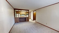 Located at 2567 Hudson Dr in Cuyahoga Falls, OH, this one-bedroom, one-bathroom unit offers a practical and efficiently organized single-floor layout. The living room is the heart of the space, featuring neutral carpet flooring, cream-toned walls with warm wood crown molding, and an open pass-through to the kitchen framed by a built-in shelving and cabinetry unit — a distinctive architectural detail that adds character while maintaining an open feel.

The kitchen is well-appointed with oak cabinetry, a teal accent wall, light tile flooring, a stainless steel sink, white electric range, and a full-size refrigerator. An adjacent utility room houses the water heater and provides additional functional space. A hallway connects the main living areas to the private bedroom, which offers carpet flooring and a generously sized reach-in closet with a hanging rod and shelf. Two additional closets throughout the unit contribute to notable storage capacity.

The bathroom includes a single-sink vanity with a wood cabinet base, a combined tub and shower unit, and tile flooring. Throughout the unit, consistent wood-tone trim and door finishes provide a cohesive, classic aesthetic. The layout makes efficient use of every square foot, delivering a complete and functional living experience.