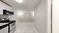 Located at 787 Vaughan Rd in Toronto's Oakwood–Vaughan neighbourhood, this self-contained studio unit offers an efficient and thoughtfully arranged single-floor layout. White large-format tile flooring runs throughout the entire space, creating a clean, cohesive look that enhances the sense of openness.

The combined kitchen and dining area is a functional highlight of the unit. The kitchen is equipped with stainless steel appliances — including a refrigerator, electric range with over-the-range microwave, and a dishwasher — all set against crisp white cabinetry and a mosaic tile backsplash in neutral tones. A drop ceiling with flush-mounted lighting keeps the space bright and well-lit throughout.

The bedroom offers a quiet, simply finished space with wall-mounted sconce lighting on either side and a window fitted with vertical blinds, allowing for natural light and privacy control. A dedicated closet provides practical storage.

The bathroom is finished with white wall tiles accented by a bold black mosaic border, giving it a clean, classic aesthetic. It includes a toilet, vanity with sink, and a framed mirror, all neatly arranged within a compact footprint.

Overall, the unit presents a no-frills, functional design with consistent finishes throughout, well-suited for those seeking a practical and accessible living space in central Toronto.