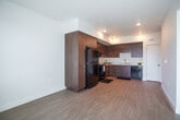 Located at 5301 Elm Ln in Oakley, CA, this one-bedroom, one-bathroom residence offers a thoughtfully designed single-floor layout with modern finishes and efficient use of space. The open-concept living, dining, and kitchen area serves as the heart of the home, featuring light wood-tone flooring that creates a bright, cohesive atmosphere. The kitchen is well-appointed with warm wood-grain cabinetry extending to the ceiling for ample storage, clean white countertops, black appliances including a refrigerator, range, and dishwasher, and recessed lighting overhead. The bedroom is a calm, comfortable retreat with plush carpeting, crisp white walls, and a window offering a pleasant outdoor view with natural light. Three closets throughout the unit provide generous storage. The bathroom includes a vanity with wood-tone cabinetry, a light countertop, and a full tub-shower combination. Additional conveniences include a dedicated laundry area and hallway spaces that enhance circulation through the home. A private balcony adds an outdoor extension to the living space. The overall design is clean and contemporary, making this a functional and comfortable residence in Oakley, CA.