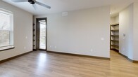 Located at 871 Oak Meadow Dr in Franklin, TN, this well-appointed one-bedroom, one-bathroom residence offers a thoughtfully designed single-level layout. The open-concept living area seamlessly connects the kitchen, dining, and living spaces, creating a bright and functional environment. The modern kitchen is a standout feature, boasting white shaker cabinetry, light quartz countertops, a center island with an undermount sink, pendant lighting, and a full suite of stainless steel appliances including a refrigerator, electric range, microwave, and dishwasher. A built-in wine rack and beverage cooler add a distinctive touch to the dining area. Light wood-look flooring flows throughout the main living spaces, complemented by ceiling fans and natural light from large windows. The bedroom features plush carpeting, a ceiling fan, ample natural light through multiple windows, and direct access to a walk-in closet. The bathroom offers a glass-enclosed walk-in shower with clean tile surround and large-format tile flooring. Additional conveniences include a dedicated laundry area, hallway storage, and richly accented interior doors with dark frames that add a contemporary contrast to the neutral palette throughout.