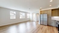 This 870-square-foot, single-floor apartment at 30950 Hanover Ln, Unit 11-306, in Menifee, CA offers a clean, modern aesthetic with quality finishes throughout its two bedrooms, one bathroom, and open-concept kitchen and living area. The kitchen is a standout feature, equipped with stainless steel appliances including a Samsung gas range, over-the-range microwave, dishwasher, and refrigerator. Taupe shaker-style cabinetry, quartz countertops, a white subway tile backsplash, and light wood-look flooring give the kitchen a contemporary, polished look. The living area extends from the kitchen and features the same light wood flooring, neutral walls, and access to an outdoor balcony through a glass door framed by large windows that fill the space with natural light. Both bedrooms are carpeted in warm neutral tones and include windows with views of the surrounding neighborhood. The primary bedroom measures 140 square feet and features two closets, including a walk-in closet with wire shelving. The shared bathroom is bright and clean, featuring a tiled shower-tub combo, wood-look flooring, and a vanity with a gray countertop. Two dedicated closets and a hallway complete the functional layout of this well-appointed home.