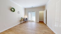 Located at 10109 Ardmore Springs Circle in Greenville, SC, this efficiently designed one-bedroom, one-bathroom home offers a thoughtful layout across a single floor. Warm hardwood-style flooring flows consistently throughout the space, creating a cohesive and inviting ambiance. The kitchen stands out as a highlight, featuring rich warm-toned cabinetry that reaches the ceiling, granite-look countertops, stainless steel appliances including a refrigerator and range, a dishwasher, and track lighting accented by crown molding — a polished and functional cooking space. The living area is open and airy, bathed in natural light from sliding glass doors that lead to an outdoor access point, complemented by crown molding details that add a refined touch. The bedroom is generously proportioned, offering a walk-in closet and a window with natural light. A dedicated laundry room provides added convenience, equipped with washer and dryer hookups, wire shelving, and its own storage area. The bathroom features a full tub-shower combination in a clean, neutral finish. Throughout the home, neutral wall tones and consistent flooring create a calm, move-in-ready atmosphere well-suited for comfortable everyday living.