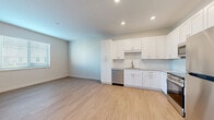 Located in Bradenton, FL, this well-appointed one-bedroom, one-bathroom unit offers a thoughtfully designed layout with modern finishes throughout. Light wood-look flooring flows seamlessly across the open living and kitchen area, creating a bright, cohesive atmosphere enhanced by recessed lighting.

The kitchen is a standout feature, outfitted with crisp white shaker-style cabinetry extending to the ceiling, granite countertops, a subway tile backsplash, and a full suite of stainless steel appliances including a refrigerator, range, built-in microwave, and dishwasher. The open-concept design connects the kitchen directly to the living area, which receives natural light through a large window.

The bedroom offers a comfortable footprint with light wood flooring, a ceiling fan, and access to a dedicated walk-in closet equipped with wire shelving for organized storage.

The bathroom is finished with striking marble-look tile on both the floor and tub surround, complemented by a white vanity with granite countertop, gold-toned hardware, and a well-lit mirror. A stacked in-unit washer and dryer is conveniently tucked into a dedicated laundry nook just outside the bathroom, adding everyday practicality to the space.