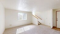 This two-story residence offers a well-organized layout comprising three bedrooms, four bathrooms, a living room, kitchen, two staircases, hallways, and a closet. The main floor hosts the living room, which is a bright and open space featuring plush wall-to-wall carpeting, a large window with vertical blinds that allows generous natural light to fill the room, and a carpeted staircase with a warm wood handrail leading to the upper level. The kitchen is thoughtfully equipped with light wood cabinetry, laminate countertops, a stainless steel sink, a black electric range, a dishwasher, and tile flooring — providing a practical and efficient cooking space. The upper floor accommodates the bedrooms, including a spacious primary bedroom with carpeted floors and a dedicated closet. Additional bedrooms are well-proportioned, carpeted, and feature windows that bring in natural light. The four bathrooms are finished with tile flooring, wood vanities with stone-style countertops, and framed glass shower enclosures, offering a clean and functional design. Throughout the home, neutral tones, textured ceilings, and consistent flooring choices create a cohesive and comfortable living environment across both levels.