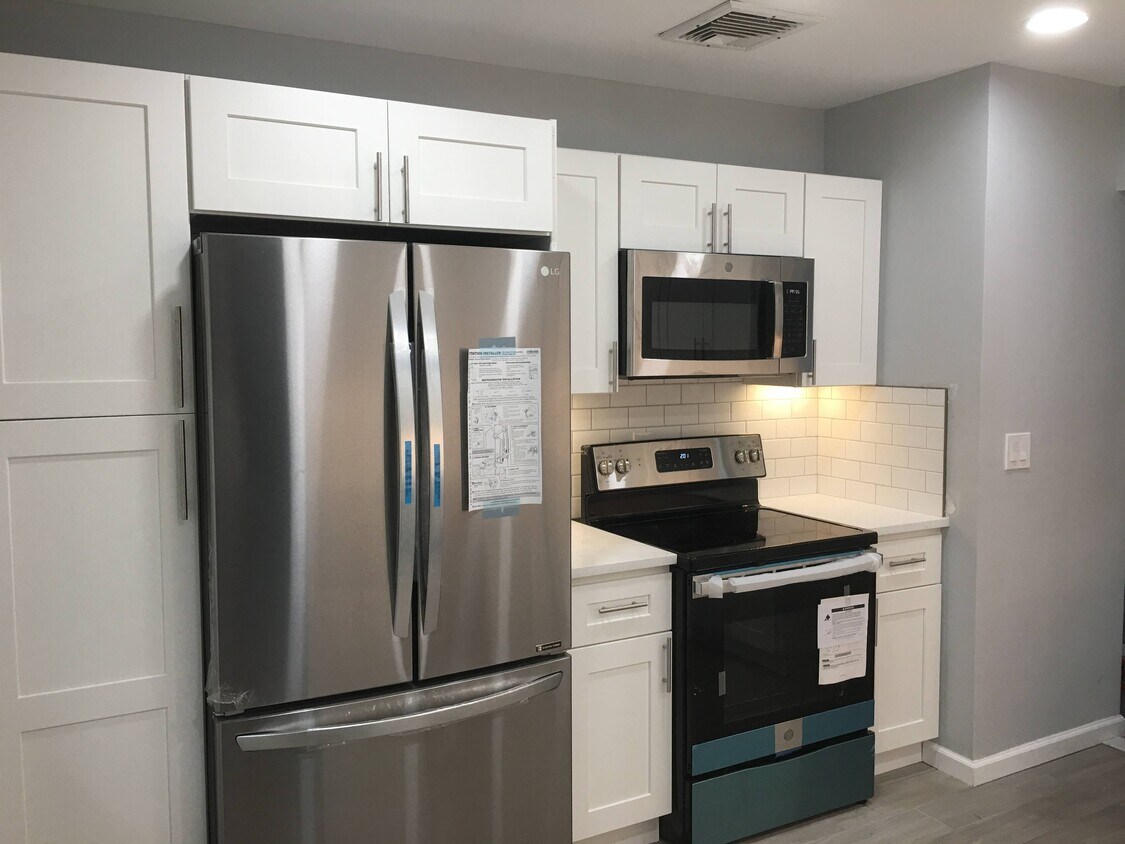 Kitchen includes stainless steel over the range microwave, electric range, refrigerator. - 12 Mill Street