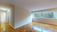 This single-floor residence offers a clean, functional layout with a cohesive design throughout. The most distinctive feature is the warm, polished parquet wood flooring that extends across the living areas and bedrooms, adding a timeless character to every room.

The spacious living area is bathed in natural light through a wide, multi-pane window that overlooks an exterior brick facade, creating a bright and airy atmosphere. Neutral-toned walls complement the warm wood floors, lending the space a calm and versatile aesthetic.

The kitchen is well-equipped with rich, dark espresso-finish cabinetry, light granite-style countertops, a stainless steel double sink, and a dishwasher. The light tile flooring provides a clean contrast to the darker cabinetry, creating a practical and stylish culinary space.

The bedrooms continue the parquet flooring theme, each offering ample space and natural light from exterior-facing windows. One bedroom includes a built-in closet with a rod and shelf system, providing functional storage. An additional room offers flexible use as a bedroom or living space.

The bathroom features tile flooring, a dark vanity with a white countertop basin, and a mirror, maintaining the consistent, modern aesthetic found throughout the residence. Overall, the space presents a practical and comfortable living environment with consistent finishes and thoughtful details.