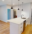 This contemporary 580 square foot apartment in London, Ontario, offers a thoughtfully designed living space. The open-concept layout seamlessly integrates the kitchen, living, and dining areas, creating a sense of spaciousness. The kitchen is a standout feature, boasting crisp white cabinetry, stainless steel appliances, and a generous island with pendant lighting, perfect for casual dining or food preparation.

The bedroom, measuring 120 square feet, is well-proportioned and features a large window that floods the space with natural light. A notable design element is an accent wall painted in a soothing blue-grey tone, adding visual interest to the room. The bathroom is modern and functional, with a white tub-shower combination and dark accents for contrast.

Throughout the apartment, warm wood flooring adds warmth and continuity. Large windows in the living area and bedroom not only brighten the space but also offer picturesque views of the surrounding landscape. The unit includes a separate laundry room with modern appliances, enhancing the apartment's convenience.

The overall aesthetic is clean and minimalist, with a neutral color palette that creates a calm and inviting atmosphere. This efficient one-bedroom apartment combines style and functionality, making it an ideal living space for individuals or couples seeking a modern urban lifestyle.