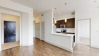 Located at 2222 Smith St in Houston, TX, this single-floor 2-bedroom, 2-bathroom residence offers a thoughtfully designed open-concept layout. The kitchen is a standout feature, showcasing rich dark cabinetry, stainless steel appliances, a subway tile backsplash, and a sleek white peninsula with pendant lighting overhead — seamlessly connecting to the dining and living areas. Wood-look flooring flows throughout the main living spaces, complemented by crisp white walls and recessed lighting that create a bright, modern ambiance. Large windows in the living area and bedrooms invite generous natural light. The bedrooms are carpeted for comfort; the primary bedroom includes a spacious walk-in closet with built-in wire shelving. The primary bathroom features a dual-sink vanity with a white quartz countertop, dark cabinetry, a large framed mirror, and a tiled shower with decorative diamond-pattern accents. Additional highlights include six closets providing ample storage, a dedicated laundry area, a pantry, and three hallways ensuring a functional flow. Ceiling fans in the bedrooms add practical comfort. This well-organized residence balances modern finishes with everyday functionality.