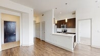 Located at 2222 Smith St in Houston, TX, this single-floor 2-bedroom, 2-bathroom residence offers a thoughtfully designed open-concept layout. The kitchen is a standout feature, showcasing rich dark cabinetry, stainless steel appliances, a subway tile backsplash, and a sleek white peninsula with pendant lighting overhead — seamlessly connecting to the dining and living areas. Wood-look flooring flows throughout the main living spaces, complemented by crisp white walls and recessed lighting that create a bright, modern ambiance. Large windows in the living area and bedrooms invite generous natural light. The bedrooms are carpeted for comfort; the primary bedroom includes a spacious walk-in closet with built-in wire shelving. The primary bathroom features a dual-sink vanity with a white quartz countertop, dark cabinetry, a large framed mirror, and a tiled shower with decorative diamond-pattern accents. Additional highlights include six closets providing ample storage, a dedicated laundry area, a pantry, and three hallways ensuring a functional flow. Ceiling fans in the bedrooms add practical comfort. This well-organized residence balances modern finishes with everyday functionality.
