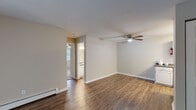 Located at 1664 N Greenfield Cir NE in Grand Rapids, Michigan, this two-bedroom, one-bathroom single-floor unit offers a practical and well-organized layout. The living area features dark hardwood-style flooring, neutral-toned walls, and a ceiling fan with light fixture overhead. Baseboard heating runs along the perimeter, providing consistent warmth throughout. A separate entrance door leads directly into the living space, which flows into the kitchen and bedroom areas.

The kitchen is equipped with white cabinetry, dark countertops, and black appliances including a range, dishwasher, and refrigerator. A built-in sink and overhead flush lighting complete the functional cooking space.

Both bedrooms are carpeted and include ceiling fans, baseboard heating, and sliding or hinged closets with built-in hanging rods. Natural light enters through windows that offer views of surrounding greenery. One bedroom also features a wall-mounted air conditioning unit and vertical blinds.

The bathroom includes a single-sink vanity with dark countertop, a toilet, and a tub-shower combination. Hardwood-style flooring extends into the bathroom, maintaining a cohesive look throughout the unit.