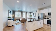 Located at 805 N 97th Ave in Tolleson, Arizona, this single-story home offers a thoughtfully designed open-concept layout that seamlessly connects the kitchen, dining, and living areas. The kitchen is outfitted with white shaker cabinetry, dark countertops, stainless steel appliances, and a central island with bar seating — ideal for both everyday cooking and entertaining. The living room features light hardwood-style flooring, a ceiling fan, and large windows that invite abundant natural light. The dining area is an intimate space highlighted by natural wood tones and stylish window treatments. A dedicated office provides a bright, functional workspace with its own window and ceiling fan. The primary bedroom is a comfortable retreat with a walk-in closet and an ensuite bathroom, while the second bedroom also benefits from generous natural light and ceiling fan. Three bathrooms serve the home, and a full-size in-unit laundry area adds everyday convenience. Three closets offer ample storage throughout. The home's consistent use of light-toned walls, wood-look flooring, and recessed lighting creates a clean, modern aesthetic throughout every room.