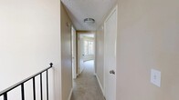 Located at 2951 Tachevah Dr in Santa Rosa, CA, this 2-bedroom, 1-bathroom space offers a practical and efficient single-floor layout. The interior is finished with neutral warm-beige walls and soft carpeting throughout, creating a cohesive and understated aesthetic across all rooms. Textured ceilings add a classic touch to each space.

The primary bedroom is the most generously sized room, featuring a large sliding window that frames lush, verdant views of the surrounding trees, flooding the space with natural light. The second bedroom shares a similar design, also benefiting from a wide window overlooking the greenery outside, making both rooms feel bright and connected to nature.

A central hallway links the bedrooms, bathroom, and closet, providing an organized flow throughout the unit. The staircase railing visible in the hallway indicates an upper-floor position within the building. The full bathroom includes a combined tub and shower with a handheld showerhead and chrome fixtures, set against clean white surrounds with wood-look flooring for a tidy, functional finish. A dedicated closet provides additional storage. The overall ambiance is clean, calm, and move-in ready, well-suited for those seeking a straightforward living space in the heart of Santa Rosa.