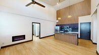 Located on Village Run Pkwy in Little Rock, AR, this thoughtfully designed two-bedroom, two-bathroom residence offers a compelling blend of modern aesthetics and functional living. The open-concept living and kitchen area is defined by dramatically soaring ceilings, a ceiling fan overhead, and light-toned hardwood flooring that flows throughout the space. A sleek electric fireplace anchors the living area, adding warmth and character.

The kitchen is a standout feature, showcasing a floor-to-ceiling slatted wood accent wall, dark upper cabinetry, crisp white lower cabinets, granite countertops, a tile backsplash, stainless steel appliances, and a breakfast bar illuminated by stylish pendant lighting. The space is open and bright, with the high ceilings lending an airy, loft-like quality.

Both bedrooms are comfortably sized and share the same warm hardwood flooring. The primary bedroom benefits from high ceilings and a ceiling fan, while the second bedroom features a window with natural light. Each bathroom is well-appointed — one offers a tiled walk-in shower with black-framed glass doors and a wood-tone vanity with granite counters, while the second features a full soaking tub and shower combination with a matching vanity. A dedicated laundry room houses a full-size Whirlpool washer and dryer, completing this well-equipped residence.