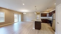 Located at 48 Bavarian Way in Altamont, NY, this well-appointed 2-bedroom, 2-bathroom single-floor home offers a thoughtfully designed layout with modern finishes throughout. The heart of the home is an open-concept kitchen and living area, where light hardwood-style flooring flows seamlessly from the kitchen island to the expansive living space. The kitchen is outfitted with rich dark cabinetry, granite countertops, a decorative tile backsplash, and a full suite of stainless steel appliances. A central island with a sink adds both functionality and style, while pendant lighting and a chandelier lend warmth to the space. Sliding glass doors in the living area provide natural light and outdoor access. Both bedrooms are generously sized, featuring ceiling fans, natural light from multiple windows, and ample closet space—three closets in total. The spacious primary bedroom offers a comfortable retreat. The two bathrooms are finished with granite-topped dark wood vanities and tile flooring; one includes a walk-in shower, the other a full tub. Additional conveniences include a dedicated laundry area, a pantry, and recessed lighting throughout. The home presents a clean, modern aesthetic with a neutral color palette.
