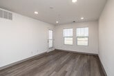 Located at 123 Mission Cir in Waterloo, Iowa, this thoughtfully designed single-floor unit offers a clean, modern aesthetic throughout. Light-toned hardwood-style flooring flows seamlessly across every room, creating a cohesive and inviting atmosphere. The open living area is bright and airy, with recessed lighting and multiple windows that invite natural light and offer views of the surrounding landscape. A glass-panel door provides additional light and outdoor access. The kitchen is well-appointed with crisp white shaker-style cabinetry, light countertops, and black appliances including a range, microwave, and dishwasher. The layout is functional and efficient, making excellent use of the available space. The bedroom is a comfortable, sunlit room featuring a window with outdoor views and direct access to a generous closet. With four closets total throughout the unit, storage is plentiful. The bathroom is spacious and clean, finished with matching light flooring, a vanity with stone-look countertop, and grab bars for added accessibility. A dedicated laundry area adds further convenience to this well-organized unit, making it a practical and polished living space.