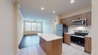 This contemporary 840 square foot apartment offers a harmonious blend of comfort and functionality. The open-concept design seamlessly integrates the kitchen and living areas, creating a spacious feel. The kitchen is a highlight, featuring sleek stainless steel appliances, abundant wood-tone cabinetry, and a practical island with a breakfast bar.

Both bedrooms are generously sized, with the primary bedroom spanning 160 square feet. Each room is equipped with large windows that flood the space with natural light and ceiling fans for added comfort. The bathrooms are modern and well-appointed, with one featuring a glass-enclosed shower.

Throughout the apartment, you'll find a mix of flooring types. The main living areas boast attractive wood-look flooring, while the bedrooms are carpeted for a cozy feel. The kitchen and bathrooms feature easy-to-maintain tile flooring.

The apartment's neutral color palette provides a blank canvas for personalization. Recessed lighting in the kitchen and living areas adds to the modern ambiance, while the large windows offer views of the surrounding area. This thoughtfully designed space combines style and practicality, making it an ideal home for contemporary living.