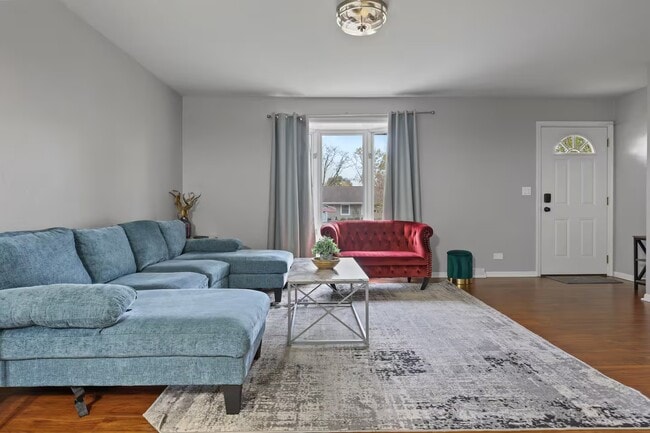 Living room with sleeper couch, smart TV and closet space. - 1002 Juniper Ln