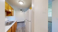 Located at 6282 12th St N in Oakdale, Minnesota, this one-bedroom, one-bathroom unit offers a practical and efficient single-floor layout. The combined living, dining, and kitchen area forms the heart of the home, featuring luxury vinyl plank flooring, warm honey-toned cabinetry, a full-size refrigerator, and a ceiling fan overhead. The open arrangement allows for flexible furniture placement and a cohesive flow between everyday living spaces. Textured ceilings are found throughout the unit, adding a classic residential character. The bedroom is a well-proportioned, carpeted room with a window that brings in natural light and views of surrounding greenery, along with baseboard heating and a closet for storage. Two additional closets elsewhere in the unit provide ample organizational space. The full bathroom features slate-toned tile flooring, a tub-shower combination with white square tile surround, a wood-toned vanity with storage, and clean, neutral finishes. The living area also benefits from a large window with outdoor views and baseboard heating, ensuring year-round comfort. This unit offers a straightforward, functional layout well-suited for individuals or couples seeking a manageable, low-maintenance living space in the Oakdale community.