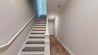 This three-story residence offers a generous 1690 square feet of living space, thoughtfully distributed across its floors. The ground level provides 160 square feet, while the first and second floors offer 720 and 810 square feet respectively. The home boasts five bedrooms, including a spacious 200 square foot primary suite, and four bathrooms for convenience.

The interior layout includes three hallways for easy navigation, a combined kitchen and living room for an open-concept feel, and a dedicated laundry room. Storage is addressed with a closet space. The home's design emphasizes natural light, as evident in the image showing a room with multiple large windows and a glass door, likely leading to an outdoor area.

Finishes include neutral-toned walls, white trim, and warm wood-look flooring, creating a bright and inviting atmosphere. The room pictured also features recessed lighting and a modern ceiling fan, adding both functionality and style. Crown molding adds a touch of elegance to the space, while the overall design appears contemporary and well-maintained.