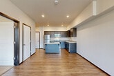 Located at 315 N Worthen St in Wenatchee, WA, this one-bedroom, one-bathroom unit offers a well-designed layout with modern finishes throughout. The open-concept kitchen and living area serves as the heart of the home, featuring warm wood-look vinyl plank flooring, recessed lighting, and a functional kitchen island with a light countertop. The kitchen is equipped with stainless steel appliances — including a refrigerator and range — complemented by rich dark cabinetry, a tile backsplash, and ample upper and lower cabinet storage. The living area flows naturally from the kitchen and opens to a private balcony through a glass door, offering stunning views of the surrounding Wenatchee mountains. The bedroom is carpeted for comfort and features large windows that frame the scenic mountain landscape, along with a wall-mounted HVAC unit for climate control. A spacious walk-in closet with wire shelving provides generous storage. The bathroom includes a full tub/shower combo with clean white finishes. The unit's neutral palette, modern fixtures, and mountain backdrop make it a comfortable and attractive living space in the heart of Wenatchee.