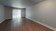 Located at 2530 Marina Dr in North Chesterfield, Virginia, this two-floor residence offers a practical and comfortable layout with a clean, neutral aesthetic throughout. The main living area features warm wood-style plank flooring and light gray walls, creating a bright and open atmosphere. A sliding glass door with vertical blinds allows natural light to pour in while providing access to the outdoors. A wall-mounted air conditioning unit and baseboard heating ensure year-round comfort.

The kitchen is equipped with white cabinetry, a double stainless steel sink, laminate countertops, and a black electric range, offering a functional setup for everyday cooking. The bedrooms are finished with plush carpeting and soft gray walls, providing a cozy and quiet retreat. One bedroom features a window with a view of surrounding greenery and a baseboard heating unit beneath it.

The bathroom presents a classic black-and-white design, highlighted by white subway tile surrounding a full bathtub and shower combination, with black accent tile trim adding a timeless contrast. A mirrored vanity area completes the space. Throughout the home, clean white baseboards and neutral tones provide a cohesive, move-in-ready feel across both floors.