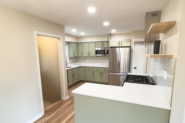 View of the kitchen from the dining area and backdoor leading to basement and backyard - 811 S 88th St