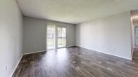 Located at 3408 Lancaster Ct in Leto, FL, this single-floor, 2-bedroom, 3-bathroom home offers a practical and comfortable layout. The living room is a welcoming space featuring durable wood-look flooring and a textured ceiling, with sliding glass doors that open to a balcony, filling the room with natural light and providing outdoor access. The kitchen is well-equipped with rich, dark wood cabinetry, granite-style countertops, and stainless steel appliances including a refrigerator and dishwasher, all set over light wood-look flooring. Both bedrooms are finished with soft, neutral carpet and light gray walls, creating a calm and restful atmosphere. The spacious primary bedroom includes ample natural light from a large window. Two closets, including a walk-in with wood-look flooring and built-in hanging rods, provide generous storage throughout. The three bathrooms are cleanly finished, featuring wood-look tile flooring, rich wood vanities with granite-style countertops, and tub-shower combinations with white tile surrounds. Clean white walls and neutral tones carry throughout the home, creating a cohesive and move-in ready feel.