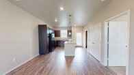 This single-story 2-bedroom, 1-bathroom unit at 6620 30th St in Lubbock, Texas offers a practical and comfortable layout across a well-utilized floor plan. The living room greets residents with warm wood-look flooring, a ceiling fan with light fixture, and large windows fitted with blinds that invite ample natural light while maintaining privacy. The space flows seamlessly into the kitchen, which is outfitted with rich dark wood cabinetry, granite-look countertops, a double-basin sink, and black appliances including a range, over-the-range microwave, and dishwasher. A window above the sink further brightens the cooking area. Both bedrooms are carpeted for comfort, each featuring a ceiling fan and windows that bring in natural light. The primary bedroom is generously sized and connects to a hallway leading to the shared full bathroom, which includes a dark wood vanity with granite-look countertop, a toilet, and a full soaking tub with shower surround. A dedicated closet with hanging rods and shelving provides organized storage. The consistent use of wood-look flooring in common areas, neutral wall tones, and practical finishes throughout give this unit a clean, cohesive, and move-in-ready appeal.
