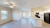 Located in Lago Vista, TX, this well-appointed 2-bedroom, 2-bathroom single-floor residence offers a clean, modern aesthetic throughout. The open-concept kitchen and living area serves as the heart of the home, featuring light wood-style luxury vinyl flooring, crisp white walls, and a ceiling fan that enhances airflow and comfort. The kitchen is outfitted with white cabinetry, light granite-style countertops, a peninsula with a double-basin stainless steel sink, pendant lighting, track lighting, and black appliances including a range and refrigerator — all flowing seamlessly into the living area, which is brightened by natural light from front-facing windows.

Both bedrooms are carpeted for comfort, each equipped with a ceiling fan. The primary bedroom offers a generous footprint with access to a walk-in closet featuring wire shelving systems for organized storage. A second closet provides additional storage elsewhere in the home.

Both bathrooms include light wood-style flooring, white vanity cabinetry, granite-style countertops, and tiled tub-shower combinations. The neutral, warm color palette used consistently throughout the space creates a cohesive and inviting atmosphere, making this Lago Vista residence a practical and comfortable place to call home.