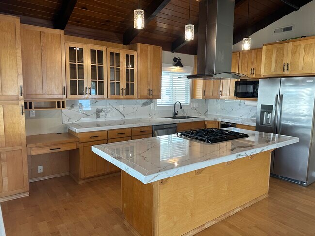 Todos los electrodomésticos nuevos y las encimeras de superficie sólida hacen que esta cocina sea lujosa. - 1879 N Jantzen Ave