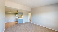 Located at 3435 Walnut Bend Ln in Houston, Texas, this single-floor, 2-bedroom, 2-bathroom unit offers a practical and comfortable layout. The open-concept living and dining area is finished with neutral-toned carpet and light gray walls, creating a clean and versatile backdrop. A half-wall peninsula separates the kitchen from the living space, providing both visual openness and functional division. The kitchen features gray upper cabinetry, white appliances including an electric range and refrigerator, light wood-look flooring, and a built-in sink along the peninsula countertop. Both bedrooms are carpeted and finished with the same neutral palette. The primary bedroom offers a comfortable footprint with natural light from a window fitted with horizontal blinds, while the second bedroom also includes a ceiling fan with light fixture and an outdoor-facing window. Each bathroom is equipped with a full tub-shower combination, a vanity, and light, clean finishes—one features wood-look flooring for added warmth. A hallway and closet complete the efficient floor plan. The overall ambiance is bright, neutral, and move-in ready.