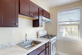 Located at 5703 43rd Ave in Hyattsville, MD, this well-appointed 1-bedroom, 1-bathroom unit offers a thoughtfully organized single-floor layout. Gleaming hardwood floors flow throughout the living, dining, and bedroom areas, lending warmth and a timeless character to the space. The living room is bright and welcoming, featuring a front entry door and an open passage into the dining area, creating a natural and connected flow between common spaces. Classic cast-iron radiators are present throughout, providing efficient and even heat during cooler months. The bedroom is comfortably sized, benefiting from two windows that invite generous natural light and views of surrounding greenery. A ceiling fan adds comfort and airflow, while closet doors offer practical storage. The kitchen is functionally designed with rich dark-stained cabinetry, marble-patterned countertops and flooring, a gas range, and a window overlooking the outdoors. The bathroom features clean white tile wainscoting, a full soaking tub, and a window with natural light, maintaining a bright and fresh atmosphere. Neutral wall tones throughout the unit create a versatile backdrop suited to a variety of interior styles. This unit offers a balanced combination of classic architectural details and practical updates.