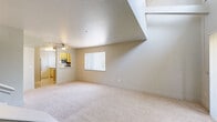 Located in Davis, CA, this two-story, 2-bedroom, 2-bathroom home offers a well-organized layout spread across two floors. The main level houses the combined kitchen and living room, which together form the largest portion of the home's footprint. The living area features soft carpeting, a ceiling fan, and a generous window with vertical blinds that allows natural light to fill the space. A staircase with a white banister connects the two floors, with an adjacent sliding glass door providing additional light and outdoor views.

The kitchen is efficiently designed with light wood cabinetry, a white quartz-style countertop, and a full suite of stainless steel appliances including a refrigerator, microwave, and electric range. Light wood-style flooring runs throughout the kitchen, offering a clean contrast to the carpeted living areas.

Upstairs, two bedrooms provide comfortable retreats, each with plush carpeting and natural light from windows with vertical blinds. The spacious primary bedroom features angled architectural ceiling details that add character. Two full bathrooms — one on each floor — include tub/shower combinations, wood-style flooring, and light wood vanity cabinetry with quartz-style countertops. Two closets and multiple hallways round out the practical and functional layout of this home.