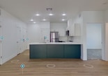 Located at 115 N 500 W in Washington, Utah, this modern single-story unit offers 960 square feet of thoughtfully designed living space across 4 bedrooms and 2 bathrooms. The open-concept kitchen serves as a visual centerpiece, featuring a large island with striking dark green cabinetry, white quartz countertops, an undermount sink, and a full suite of stainless steel appliances including a gas range, microwave, and refrigerator. White upper cabinets and recessed lighting complete the contemporary aesthetic. Light wood-look flooring extends through the main living areas, while the bedrooms are finished with neutral carpet. Each bedroom is bright and airy, with large windows dressed in white blinds that bring in ample natural light. The primary bedroom measures 160 square feet and includes a dedicated closet with a full-width hanging rod. Both bathrooms reflect the same modern design language, featuring dark green vanities with white countertops and brushed nickel hardware. The full bathroom includes a tub-shower combo with built-in shelving, while the second bathroom offers a streamlined layout. Clean white walls and consistent trim throughout the unit create a cohesive, move-in-ready aesthetic.